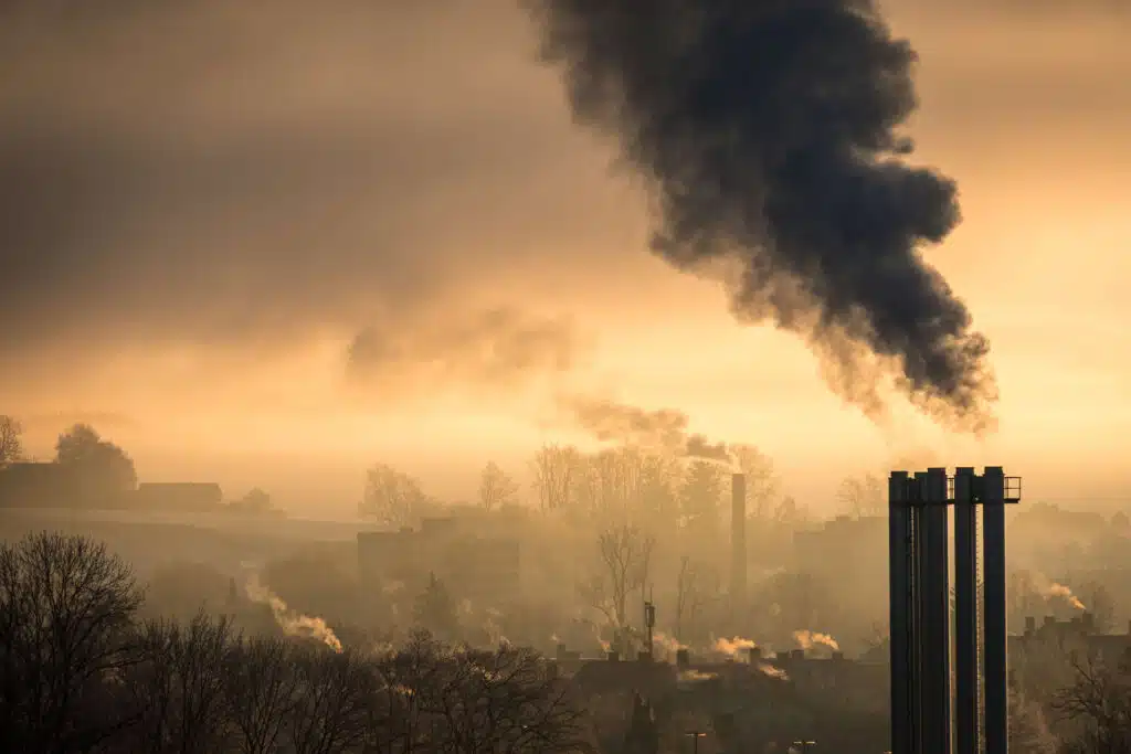 A factory chimney polluting air during sunset